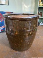 Front image of the red ware open crock showing brown glazed pottery with a slightly flared rim and smooth body.