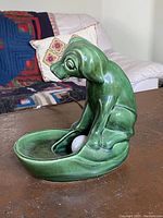 Side profile showing the green ceramic dog seated with a shallow bowl holding a bulb, TV lamp style.
