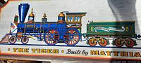 Close-up of the blue steam locomotive section of the wooden wall sign, showing detailed features and the label 'THE TIGER Built by MATTHIAS'.