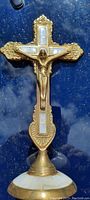 Full image of 8" vintage religious cross on blue background showing detailed crucifix and ornate gold-toned edges.