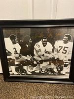 Framed photo of four Steelers players kneeling