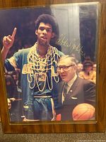 Front view of wooden plaque with autographed photo showing Kareem Abdul Jabbar and Coach Wooden, signed by Abdul Jabbar.