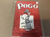 Front cover of the Pogo first book showing red cover with Pogo character and title by Walt Kelly.