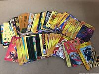 Overview of numerous Overpower Marvel and DC trading cards spread out showing colorful artwork and different characters.