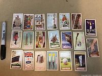Twenty laid out colorful 1924 Imperial Tobacco trade cards showing varied subjects like cricket, golf, maritime, and daily objects.