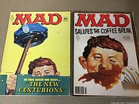 Two MAD magazines side-by-side showing front covers, No. 278 (1987) and No. 222 (1981), depicting Alfred E. Neuman with police hat and coffee stains respectively.