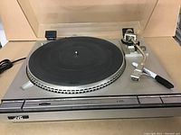 Front angled view of the vintage JVC turntable showing platter, tonearm, and control buttons.
