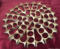 Top view of large brass decorative wall sculpture laid flat on a red fabric background
