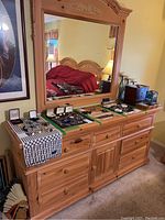 Full view of Broyhill wood dresser with large attached mirror and various jewelry items displayed on top.