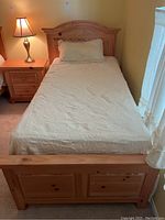 Photo of the full Broyhill twin bed made up with white bedspread and a pillow, showing headboard, side rails and footboard in wood finish.