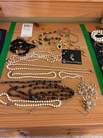 Overview of all items laid out on wooden surface including necklaces, rings, earrings, bracelet