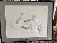 Framed charcoal art piece showing three fish swimming with an Asian signature/stamp in red at top right.
