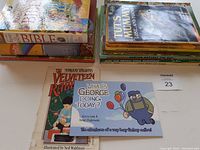 Books stacked showing titles including Bible stories, Tut's Mummy, classic adventures, and Dr. Seuss books