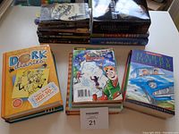 Front and top view of several stacks of young adult fiction books including Dork Diaries, Harry Potter, and a graphic novel.
