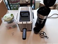 Deep fryer, boxed food chopper and coffee maker with cup and filter shown together