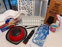 Lot contents including Vileda Virobi robotic cleaner, furniture risers, cleaning items and Ikea dish drainer