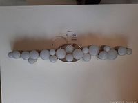 Full view of Ikea Sodervik bathroom light fixture showing nine frosted glass bulbs in a row mounted on a shiny chrome metal base.