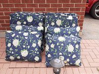 8 outdoor cushions arranged in 2 rows of 4 cushions each, showing the blue floral fabric and thickness of cushions.