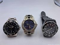 Photo of three men's diver watches from brands Toolworx, Geneva, and Freelook. Shows front faces and bands on white background.