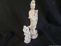 Photo of two Blanc De Chine porcelain figures on black background, showing overall appearance and scale.