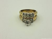 Front view of vintage ring showing clear central and smaller accent stones on yellow gold filled band