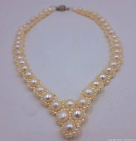 Front view of the vintage pearl choker necklace showing large central pearls surrounded by smaller ones forming a V shape.