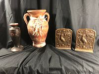 Full lot with brown pottery vase, black floral vase, and bronze bookends on black cloth