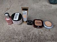 Photo of all six cosmetic products arranged in a line showing front labels and packaging variety