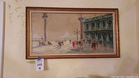 Framed vintage signed oil painting showing a cityscape with people and columns in daylight with shadows cast on a wide walkway.