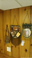 Full view of three Bedouin style hanging mirrors on wood paneled wall, showing overall design and placement