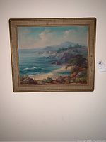 Full front view of framed oil painting showing coastal scene and frame