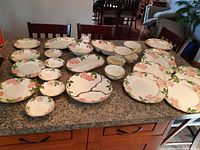 Full display of all 30 pieces of the Franciscan ware dinner set on counter.