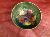Top view of the ceramic bowl showing detailed floral design and green background.
