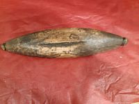 Top view of a vintage wooden rolling pin or dough tool, showing aging and surface cracks on the wood.