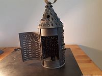 Front angled view of the Paul Revere style punched tin lantern with hinged door open showing the punched metalwork.