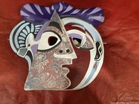 Front view showing abstract cubist face design with purple and marbled patterns