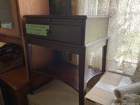 Full view of dark brown wooden side table showing top, drawer, shelf, and legs