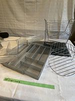 Set of drawer organizers on a white cloth background showing multiple plastic and metal pieces