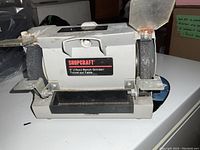 Front view showing Shopcraft label, grinding wheels with protective shields, and work rests.