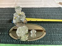 Crystal figurine of Red Riding Hood standing on oval mirrored base with measuring tape showing size.