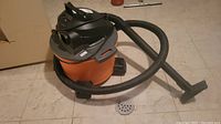 Ridgid Shop Vacuum WD06701 showing full unit with hose and nozzle on basement floor.