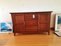 Front view of closed sideboard showing three drawers and two doors