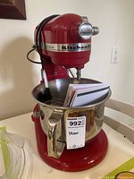 Front view showing red mixer with bowl and instruction manual inside