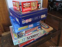 Stack of board games and puzzle boxes showing varied classic games and a tin 10 Game Set
