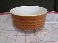 Side view of Hornsea Saffron serving bowl showing orange circular and flower pattern on exterior.