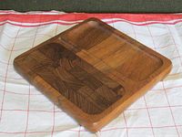 Oblique view of the teak wood board showing end grain and side grain sections, and groove edge detail.