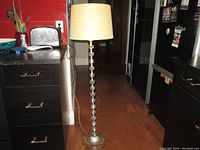 Full view of the mid century floor lamp in a kitchen setting showing its height and design.