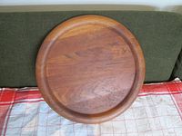 Top view of the circular teak tray showing wood grain and raised lip.