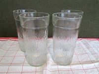 Set of four clear textured highball glasses shown together, displaying overall shape and texture.