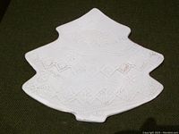 Top view of white ceramic tray shaped as Christmas tree with raised geometric and lace-like embossed patterns.